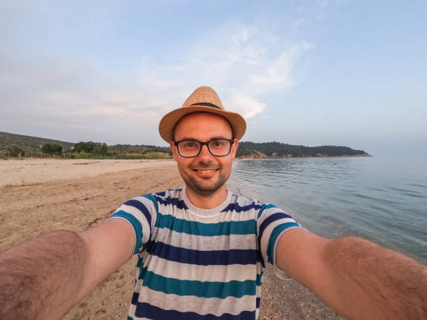 Young man taking a selfie on the beach on vacation in Thasos, Greece.