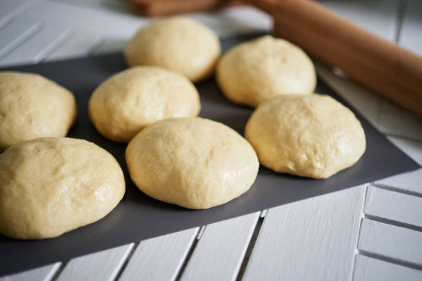 istock Dough preparation concept. Dough balls on a table in kitchen. Pizza making 1446039629