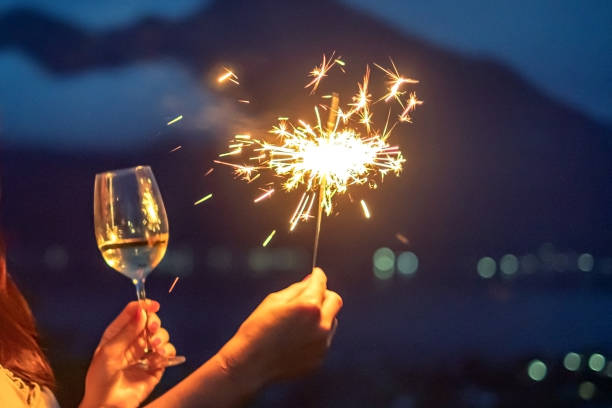 mãos femininas segurando um burning sparklers na véspera de ano novo - sparkler sparks new years eve human hand - fotografias e filmes do acervo