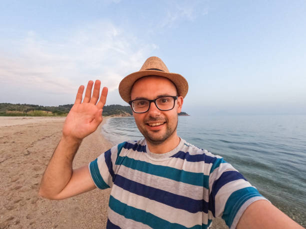 istock Young Man Having A Video Call On The Beach 1446040420