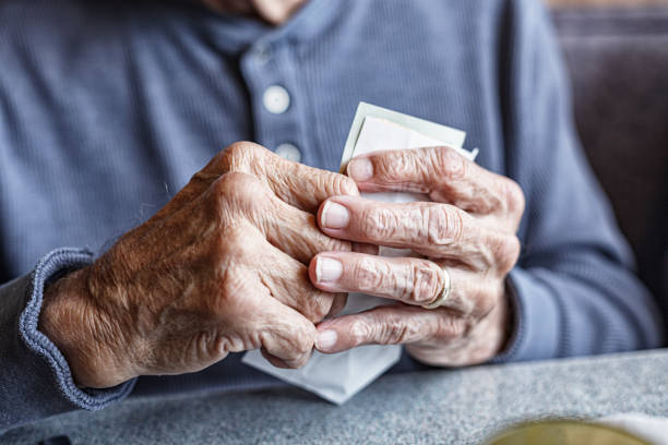 istock Elderly Man Arthritic Hands Holding Restaurant Payment Bill 1446041292