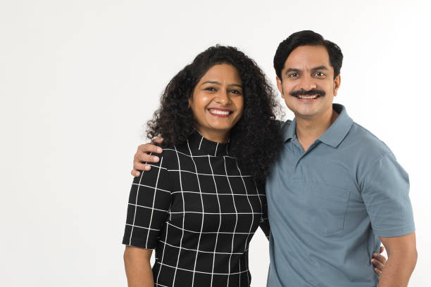 istock Cheerful couple with arms around standing on white background 1446042006