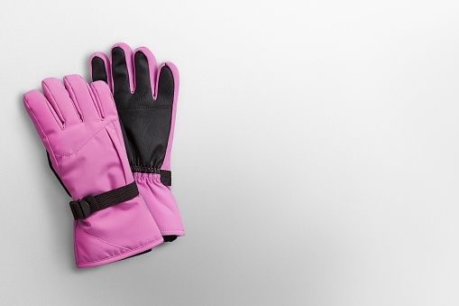 Pink winter gloves on a white background