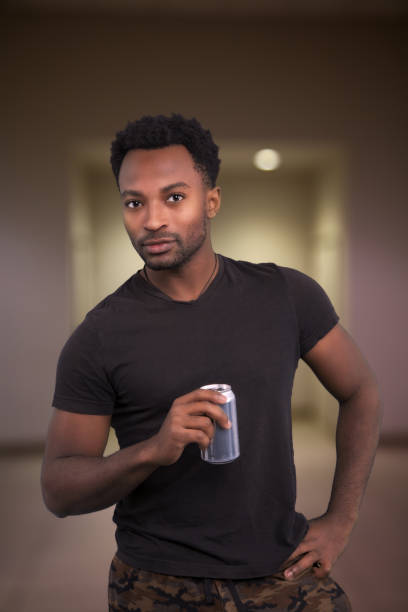 istock young man drinking soda holding can vertical portrait cool attitude 1446042679