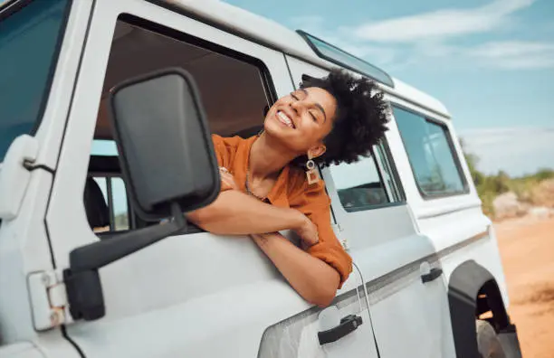 Photo of Relax black woman on road trip, happy with view of desert and transport in jeep or car on holiday in Cairo. Travel adventure drive, smile in summer vacation and explore freedom of nature in the sun