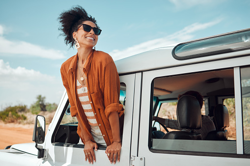 Happy black woman, desert holiday road trip and man driving jeep with body outside car window view of South Africa landscape. Couple on a travel adventure, summer vacation and explore nature together