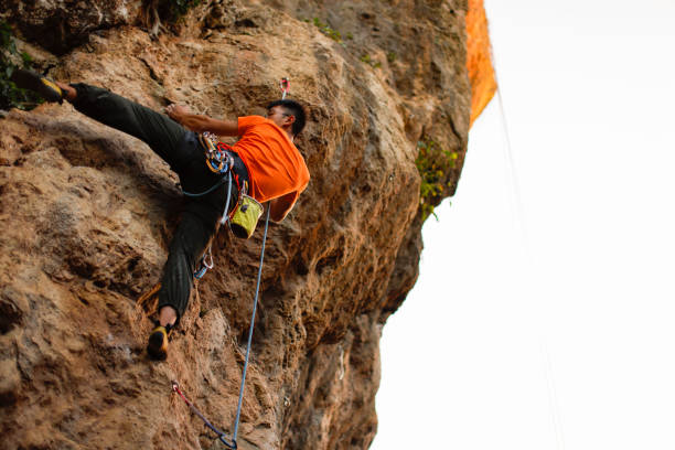 istock man challenging rock climbing on limestone wall 1446045114