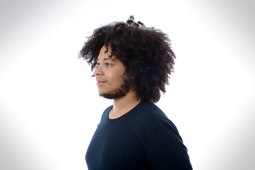Portrait of young man with afro hair in photo studio with white background