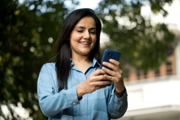 istock Smiling woman texting over mobile phone 1446048780