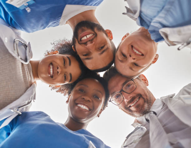 istock Team, diversity and doctors in circle from below, teamwork, support and help from hospital staff. Group of medical workers in huddle looking down head together. Teammates, men and women in healthcare 1446048932