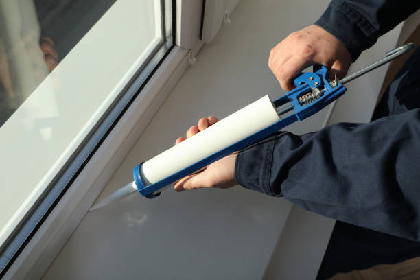 bauarbeiter fenster mit abdichtung abdichten, nahaufnahme - window caulk gun caulking installing stock-fotos und bilder