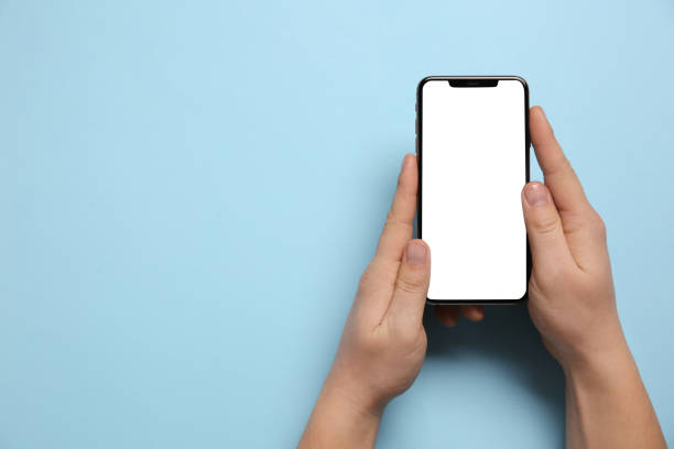 istock Woman with smartphone on light blue background, top view. Space for text 1446050295