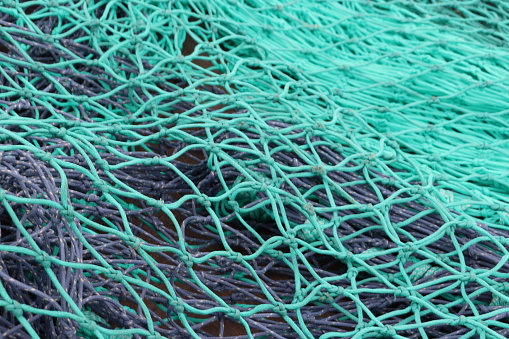 Fishing nets. Fishing nets with colorful buoys. Fishing gear and tackle. Industrial fishing. Fishing nets in the port on the floor.