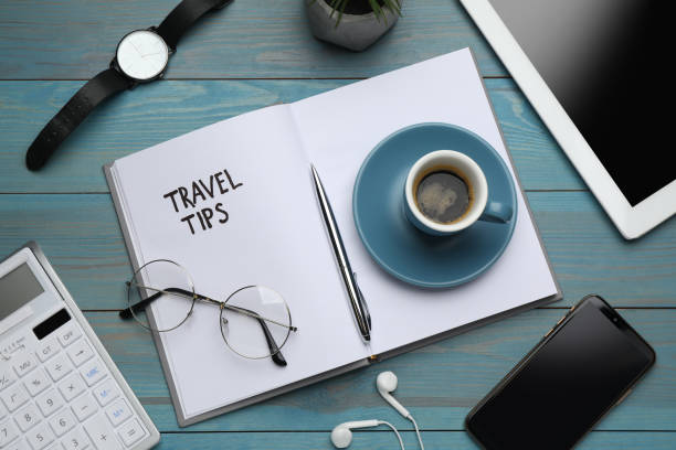 istock Notebook with phrase Travel Tips and office stationery on light blue wooden table, flat lay 1446052173