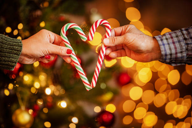 istock Couple holding Christmas candy canes making heart shape 1446052248