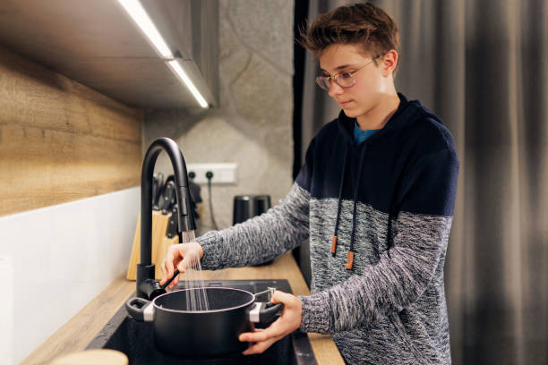 Teenagers cooking spaghetti dinner together