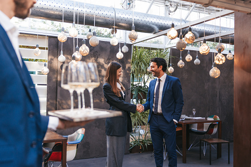 Couple of business people have an agreement during a business meeting in a luxury restaurant.