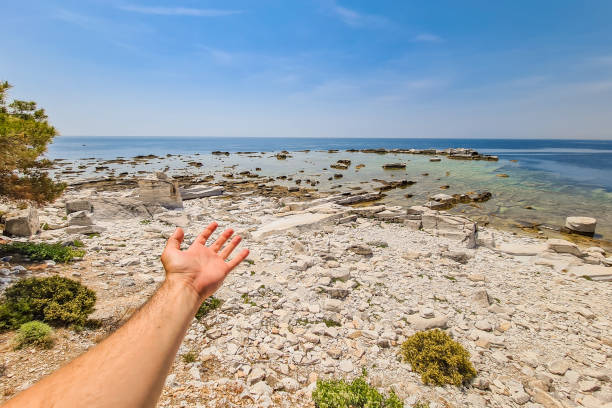 istock Young Man Showing The Beach With Ancient Marble 1446055296