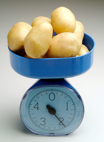 Kitchen scale weighing potatoes.