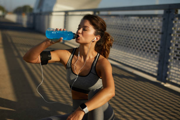 istock Sportswoman resting and hydrating on the bridge 1446056467