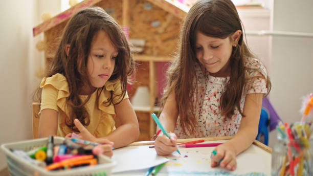 istock Sisters at home drawing and painting together 1446056582