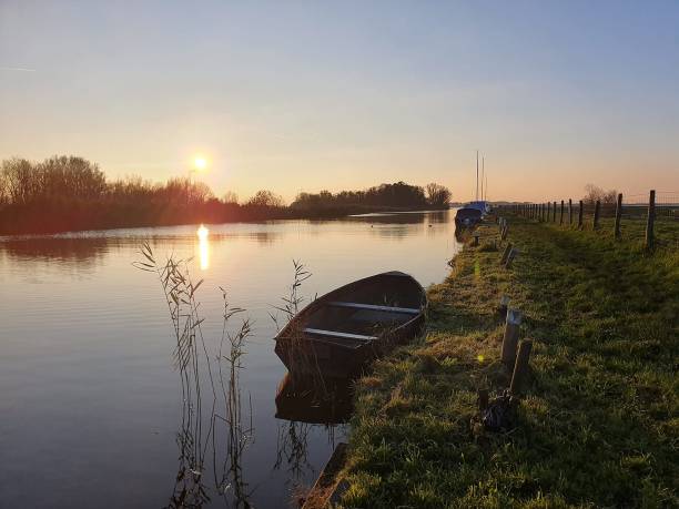 istock Rowboat docked along the shore with the sun coming through 1446057880