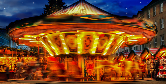 bright spinning blurred carousel at christmas market