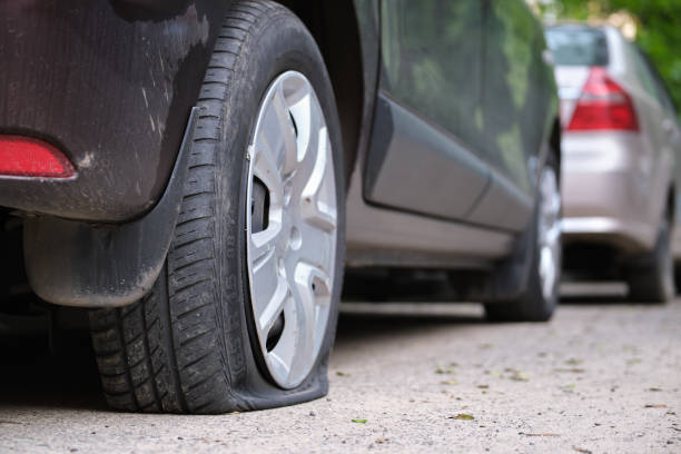 istock Car with punctured flat tire parked on roadside 1446061597