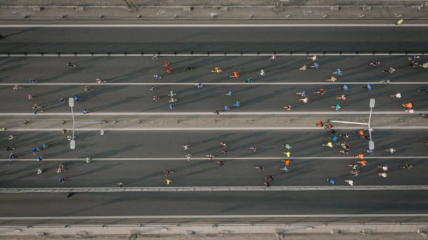 vista aérea da única maratona intercontinental do mundo, maratona da cidade, atletas correndo, vista aérea de pessoas correndo no meio da cidade, vista aérea de maratonistas, corredores, maratona de corredores de istambul - healthy lifestyle turkey sport marathon - fotografias e filmes do acervo