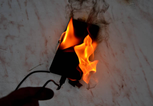 istock Cell phone battery failure. A smartphone can quickly catch fire and set fire to a house, apartment, or car. there is a risk of burns to the device user. flames surround the entire tablet laptop comp 1446067640