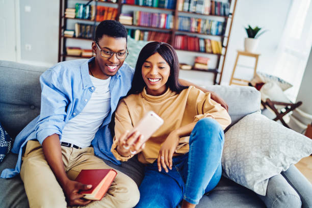 istock Happy young couple using smartphone at home 1446068085