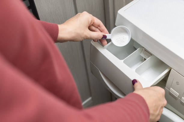 istock man pouring washing powder into the washing machine 1446068470