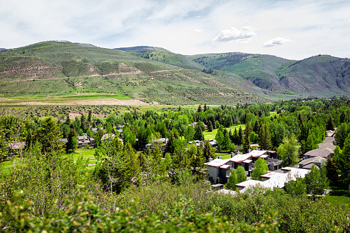 High angle aerial view on mountain town of Avon, Colorado near Beaver Creek ski resort with houses homes by golf club course in summer with green aspen trees
