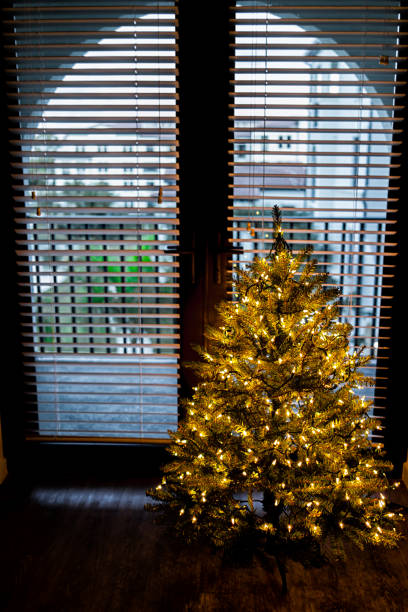 Christmas xmas New Year tree illuminated by balcony window view at evening night with ornaments festive decorations holiday pattern shiny illuminations