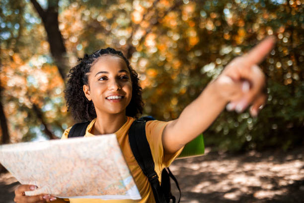 istock Young woman hiking exploring a map pointing a way 1446069405