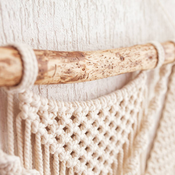 istock Handmade macrame wallhanging. Wooden stick with100% cotton wall decoration.  Macrame braiding and cotton threads. Female hobby.  ECO friendly modern concept in the interior 1446071042