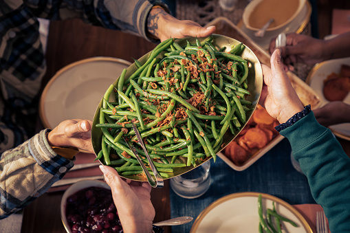 A Black family gathers together to cook and eat a Thanksgiving meal.