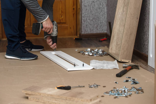 Assembling new furniture with your own hands according to the instructions, improving living conditions a male furniture craftsman assembles a cabinet case in a house. Repair and improvement of living conditions handyman stock pictures, royalty-free photos & images