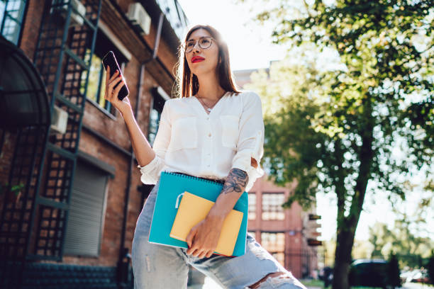 istock Charming woman browsing phone in street 1446075573