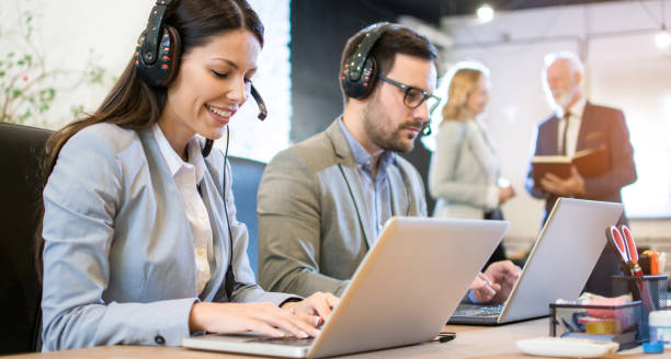 istock Beautiful call center smiling operator agent with phone headset working in office. 1446076031
