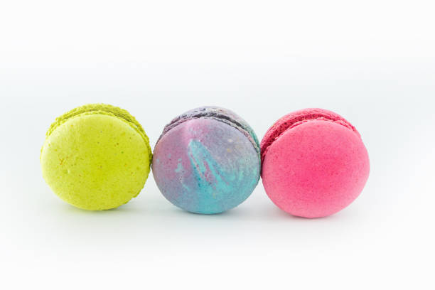 istock Brightly colored stacked macarons on white background. Tasty colorful macaroon assorted. Three sweet macaroons cakes of different colors. French pastry made from egg whites. Culinary, cooking concept. 1446076374