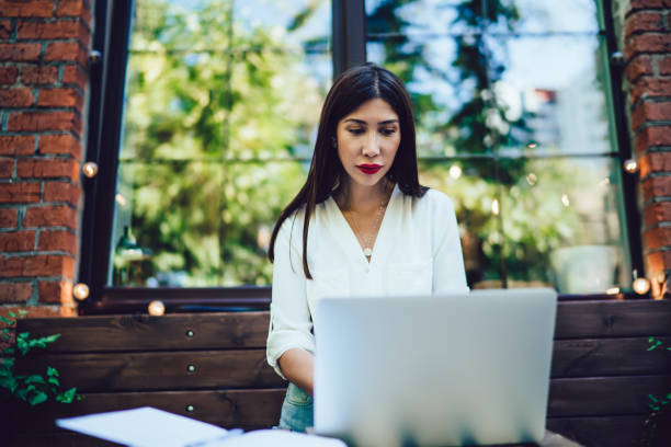 istock Young lady working with laptop in street cafe 1446077943
