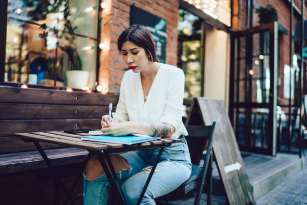 istock Serious lady making notes in notebook in street 1446077945