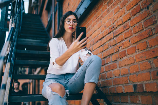 istock Woman making selfie sitting on stairs 1446077985