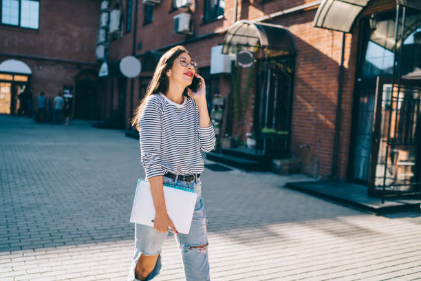 istock Content female speaking on smartphone against building 1446078019