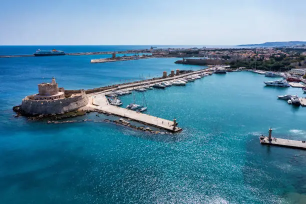 Mandraki port with deers statue, where The Colossus was standing and fort of St. Nicholas. Rhodes, Greece. Hirschkuh statue in the place of the Colossus of Rhodes, Rhodes, Greece