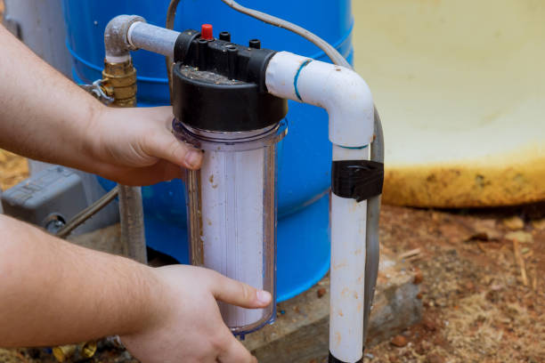 istock Replace the replaceable filters for cleaning water near the home by professional workers performing maintenance work by replacing replaceable filters in the outside parts of the house 1446080825