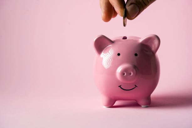 istock Hand puts a coin in a piggy bank. 1446083078