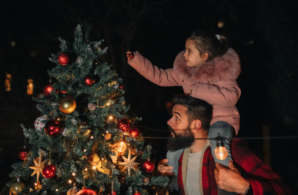 istock Dad and little girl decorating Christmas tree together 1446084270