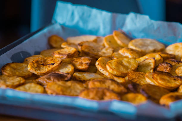 istock Sliced potato chips or dollar chips looking from above lying in a pan. Freshly baked from oven potato chunks. 1446085904